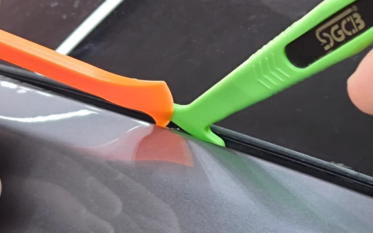 PPF filminin kenarı plastik aparatla panel boşluğuna içeri sarılırken — Peak Detailing stüdyosu